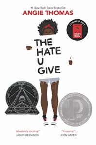 The Hate U Give book cover. Teenage girl holding a sign that says "The Hate U Give"